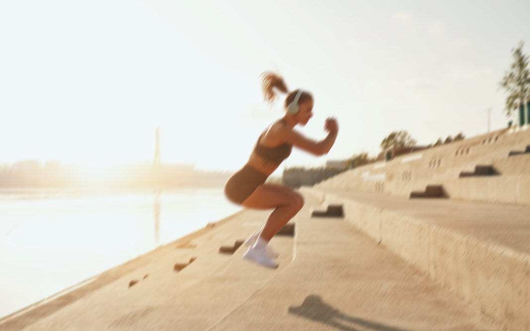Woman jumping up a set of concrete steps