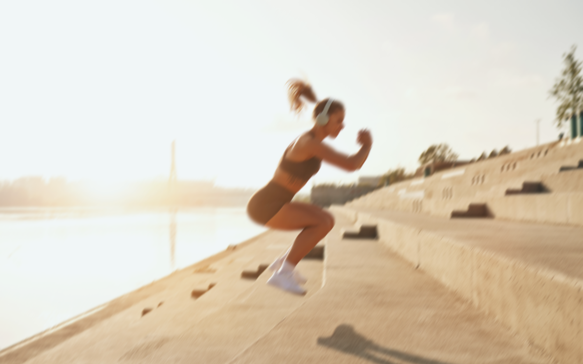 Woman jumping up a set of concrete steps