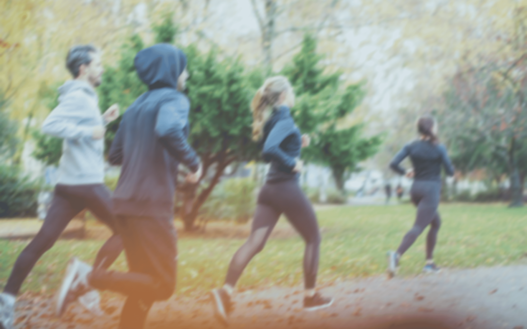 Men and women running together outside on a trail 