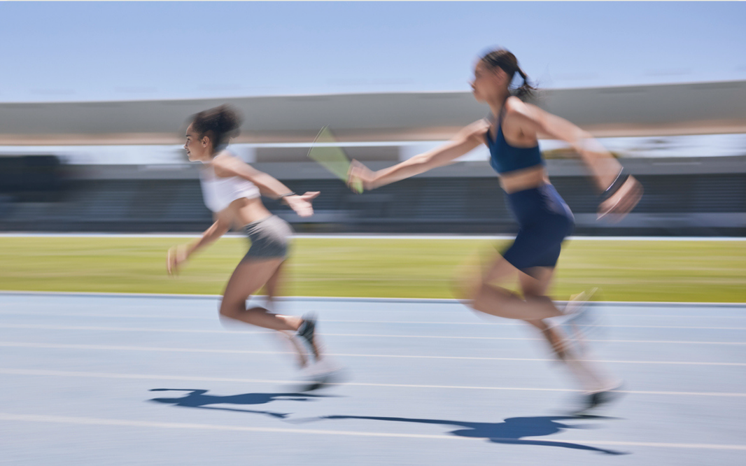 runners in a relay race passing off a baton