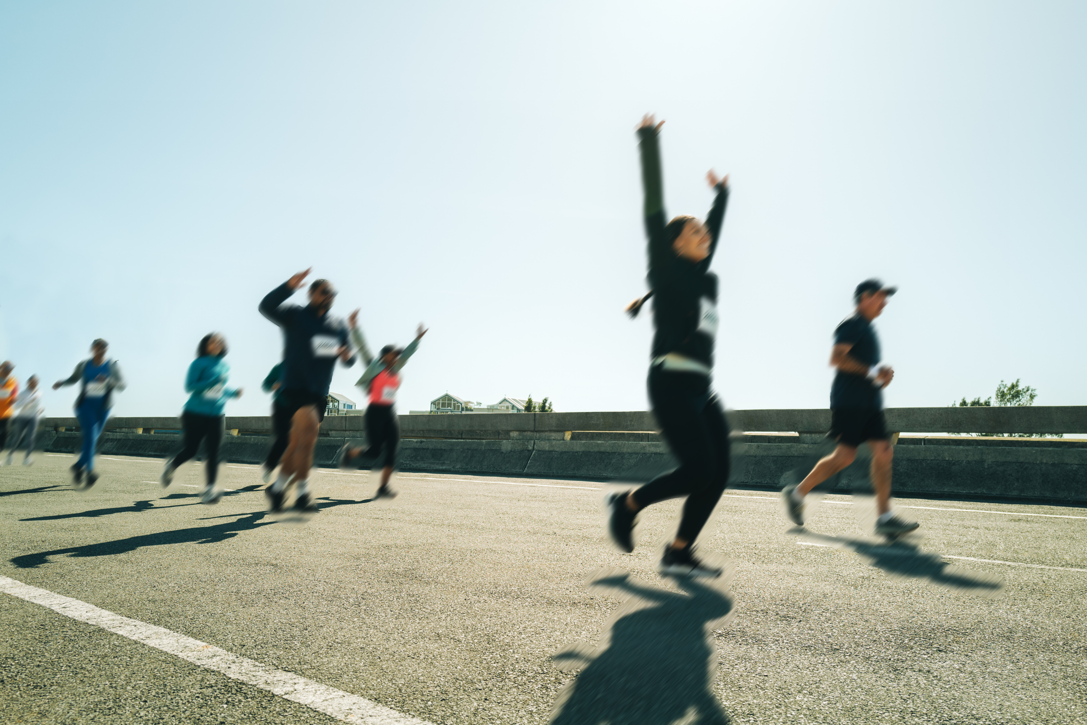 People running on a road with a clear sky