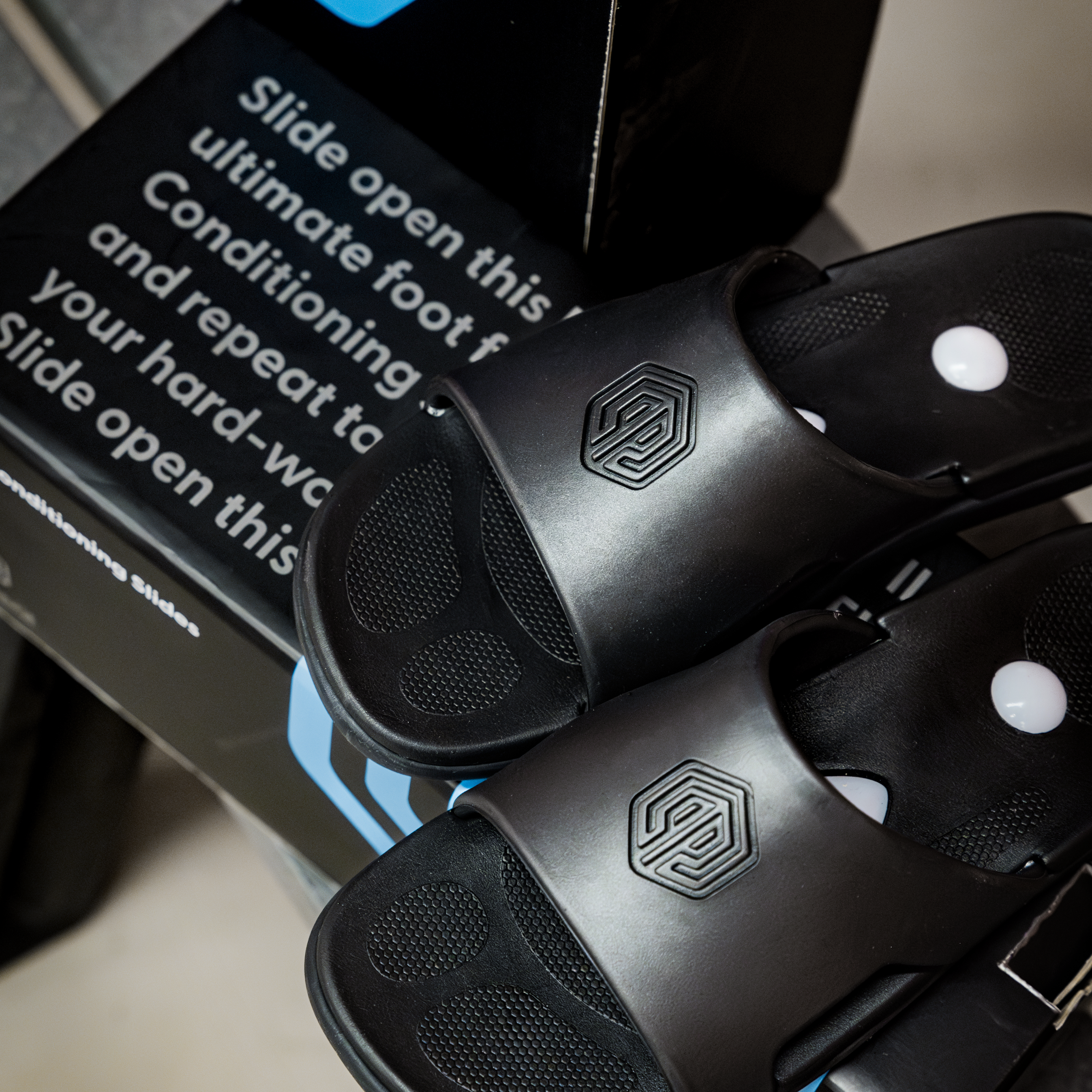 Pair of Flex 3 Fitness Slides poised atop Flex 3 Fitness Slides shoebox.