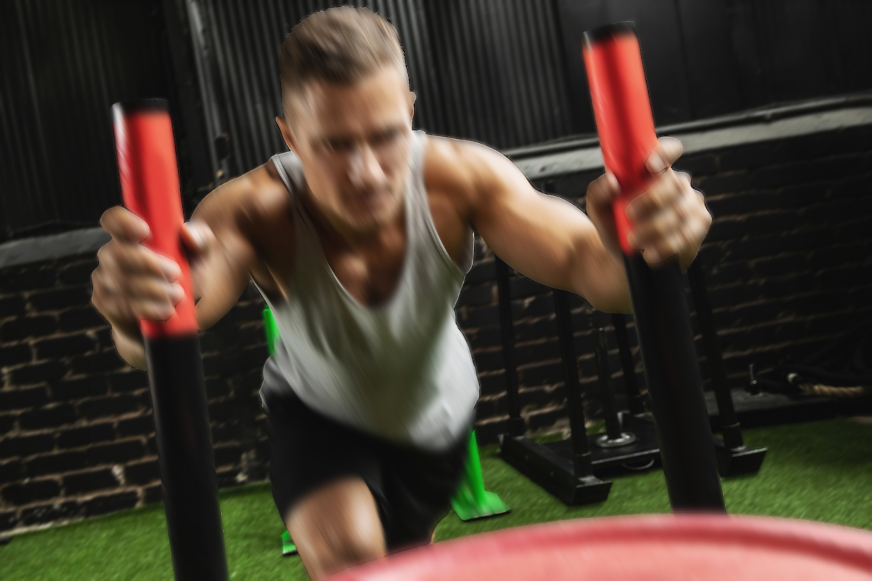 Man exercising with red resistance bands in a gym setting